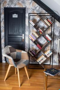 a room with a chair and a book shelf at Les chambres du Bocage - Chambre Marylin in Bressuire