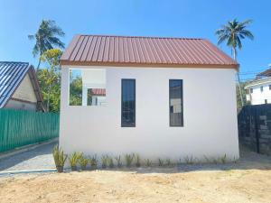 a small white house with a red roof at Lantara resort in Ko Lanta