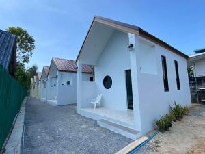a white house with a chair in the doorway at Lantara resort in Ko Lanta +3 photos
