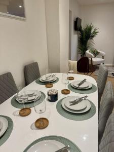 a table with plates and wine glasses on it at Charming 6 Bed Flat in Bedminster - Sleeps 8 in Bristol