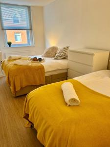 a room with two beds with yellow sheets and a window at Charming 6 Bed Flat in Bedminster - Sleeps 8 in Bristol +13 photos