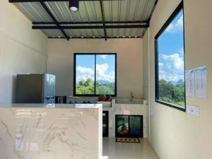 a room with two large windows in a kitchen with a counter at Yankoi Mountains view in Chiang Dao