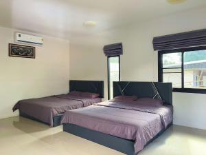two beds in a room with two windows at Yankoi Mountains view in Chiang Dao +16 photos