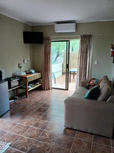 a woman laying on a couch in a living room at Kruger Bush Retreat in Marloth Park