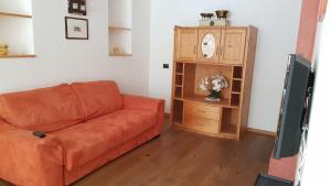 a living room with a couch and a grandfather clock at Hotel B&B Brunello in Ortisei