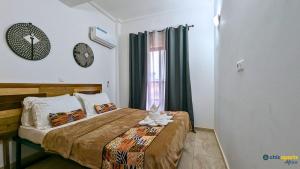 a bedroom with a bed and a clock on the wall at Studio Chic avec parking in Yaoundé