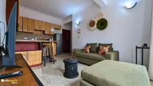 a living room with a couch and a kitchen at Studio Chic avec parking in Yaoundé