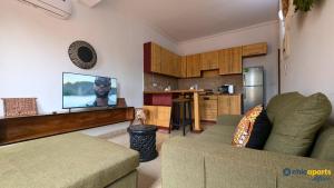a living room with a couch and a flat screen tv at Studio Chic avec parking in Yaoundé