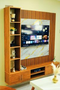 a large flat screen tv in a wooden entertainment center at Eternal shine serenity in Munyonyo