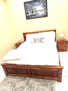 a bedroom with a bed with a wooden bed frame at Eternal shine serenity in Munyonyo