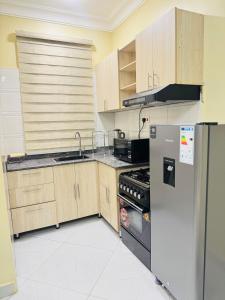 a kitchen with wooden cabinets and a stainless steel refrigerator at Eternal shine serenity in Munyonyo