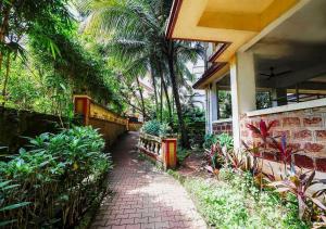 a walkway in front of a house with palm trees at Palette Susegad I 3BHK Apartment I Pool I Candolim I GOA in Candolim