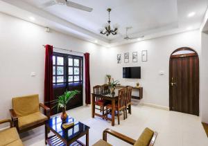 a living room with a table and a dining room at Palette Susegad I 3BHK Apartment I Pool I Candolim I GOA in Candolim