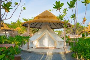 a small tent under a umbrella in a garden at Bangsaen Villa in Bangsaen