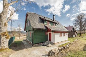 a small green and white house with a tree at Roubenka Nové Hutě in Nové Hutě