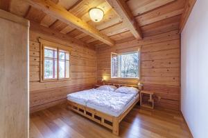 a bedroom in a log cabin with a bed at Roubenka Nové Hutě in Nové Hutě