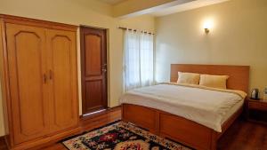 a bedroom with a large bed and a window at Hotel Norbu Sangpo in Kathmandu