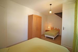 een slaapkamer met een bed, een dressoir en een kast bij Gîte Les Champs N°1 in Saint-Mathieu