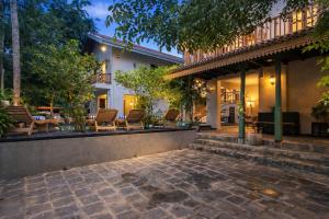 a patio of a house with chairs and trees at Aura By Epic Collection in Mirissa