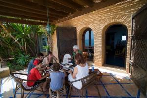 een groep mensen die rond een tafel op een patio zitten bij Villa Oceane in Taghazout