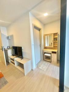 a room with a desk with a computer and a tv at Dcondo reef 99 in Kathu
