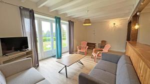 a living room with a couch and a table with chairs at Gîte 87G7453 in Saint-Mathieu