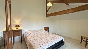a bedroom with a bed and a table with a lamp at Gîte 87G7453 in Saint-Mathieu