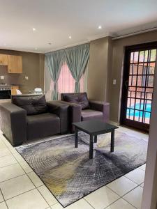 a living room with a couch and a coffee table at The N1 Farm Place in Pretoria