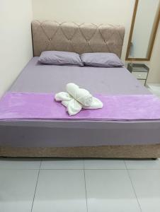 a bed with a pair of white towels on it at REZEKI MUEZZA 3BR2B Cozy Homestay in Teluk Intan +37 photos