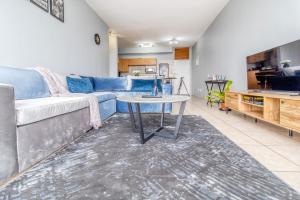 un soggiorno con un divano e un tavolo di Skyline Hideout XL King Bed FREE Parking Views a Edenvale