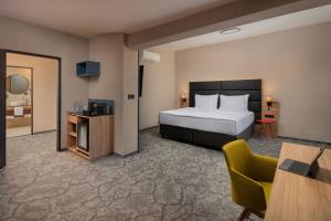 una stanza d'albergo con un letto, una scrivania e una sedia di City Inn Hotel Olomouc a Olomouc Altre 36 foto
