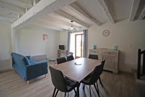 een woonkamer met een houten tafel en stoelen bij Gîte Les Champs N°4 in Saint-Mathieu +21 foto's
