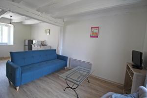 een woonkamer met een blauwe bank en een tafel bij Gîte Les Champs N°4 in Saint-Mathieu