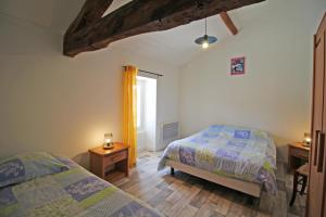 een slaapkamer met twee bedden en een raam bij Gîte Les Champs N°4 in Saint-Mathieu