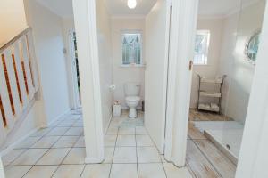 a white bathroom with a toilet in a hallway at Seabreeze in Hermanus +23 photos