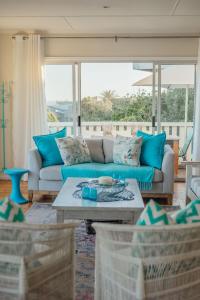a living room with a blue couch and a table at Seabreeze in Hermanus