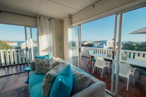 a living room with a couch and a table on a balcony at Seabreeze in Hermanus