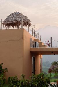 a building with a balcony and palm trees on top at Campo De Sole Villa Hoa Binh in Hòa Bình