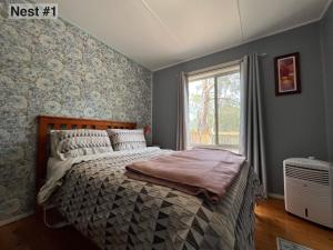 a bedroom with a bed and a window at Grampians Nest in Halls Gap