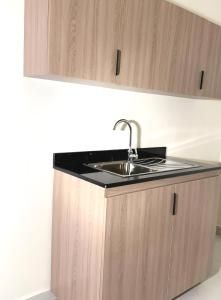 a kitchen sink with a black counter top at Bloom Hotel-Kuwait in Kuwait
