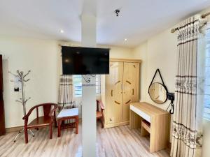 a living room with a flat screen tv on a wall at Văn Phượng Hostel in Cat Ba