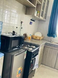 een keuken met een fornuis en een koelkast bij Zayana Homes in Meru