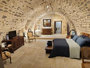 a bedroom with a bed and a stone wall at Commanderie Templière de Cazouls d'Hérault in Cazouls-d Herault