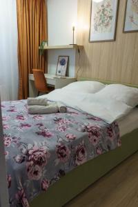 a bedroom with a bed with a floral blanket at Willa na Dębowej in Katowice