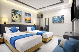 una camera d'albergo con due letti e una televisione di Hotel East End Delhi Airport With Free Airport Drop a Nuova Delhi