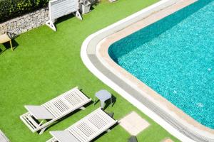an overhead view of a swimming pool with two lawn chairs at Bangsaen Villa in Bangsaen