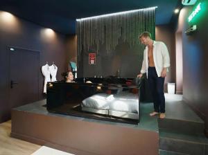 een man die naast een bed in een winkel staat bij Love Room Marseille - Aphrodisia in Marseille