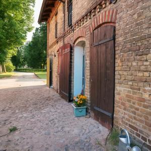 a brick building with a door and a pot of flowers at Idyllic Hideaway In The Countryside in Marienwerder