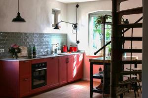 a kitchen with red cabinets and a staircase in it at Idyllic Hideaway In The Countryside in Marienwerder