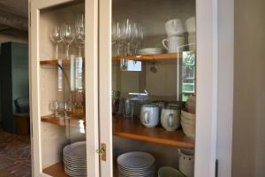 a cabinet filled with glasses and plates and dishes at Idyllic Hideaway In The Countryside in Marienwerder